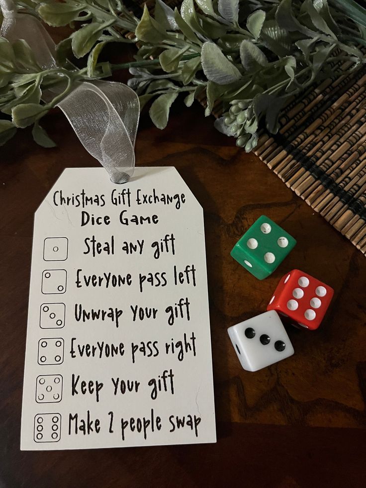 a christmas gift tag with dices sitting on top of it next to a plant