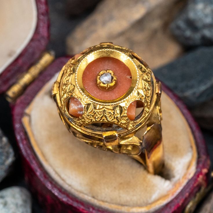 This vintage coral ring features a dome that encases a coral gem that is centered with a rose cut diamond. The coral has some movement inside the dome by design. The ring is crafted of 10k yellow gold and shows a lovely unpolished patina. Antique Diamond Cabochon Rings, Heirloom Gemstone Dome Ring For Formal Occasions, Formal Heirloom Dome Ring With Gemstone, Formal Heirloom Gemstone Dome Ring, Heirloom Style Domed Ring For Formal Occasions, Vintage Yellow Gold Enamel Ring With Rose Cut Diamonds, Heirloom Yellow Gold Dome Ring With Cabochon, Heirloom Dome Ring With Cabochon In Yellow Gold, Heirloom Dome Ring In Yellow Gold With Cabochon