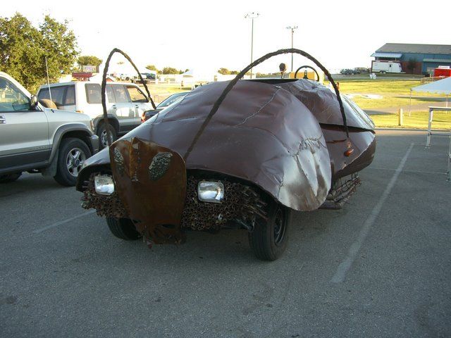 an unusual car is parked in a parking lot