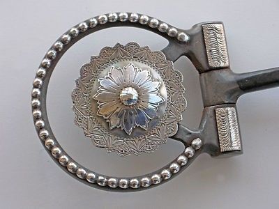 a pair of scissors with beaded handles on a white surface, one has a flower in the center