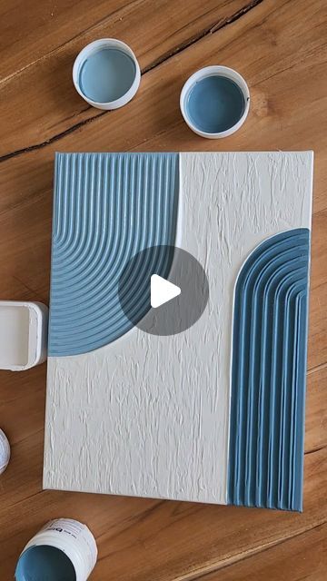 the video shows how to use blue and white paint on an unfinished piece of paper