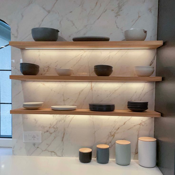 the shelves are filled with bowls and plates