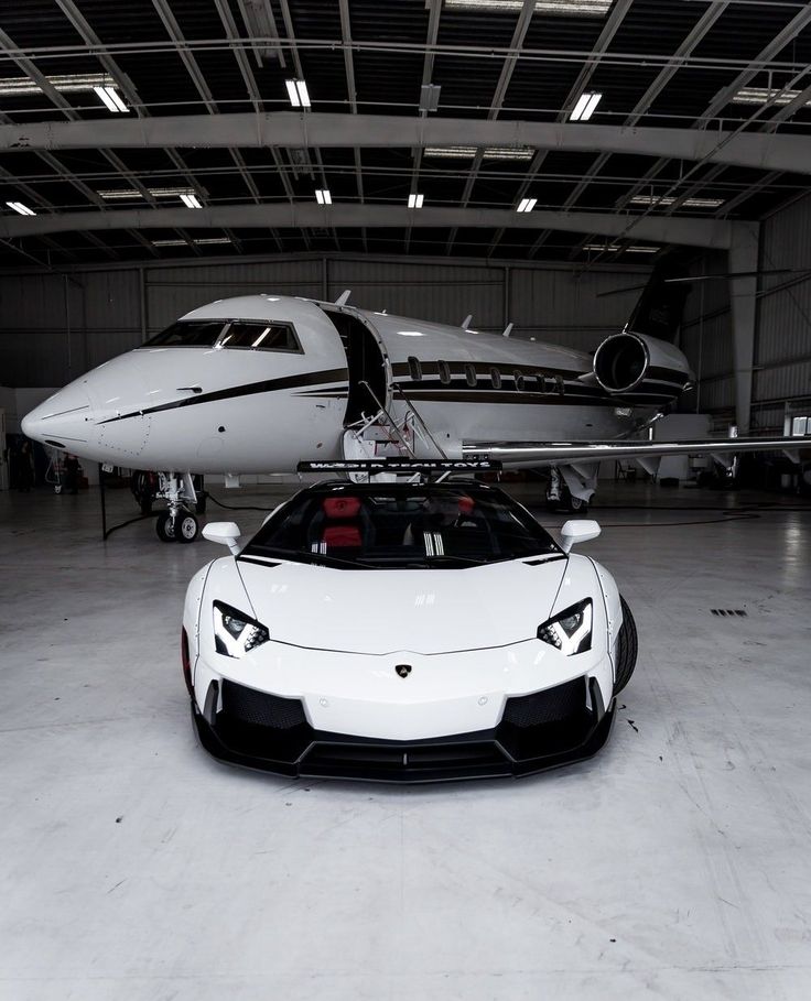 a white sports car parked in front of an airplane