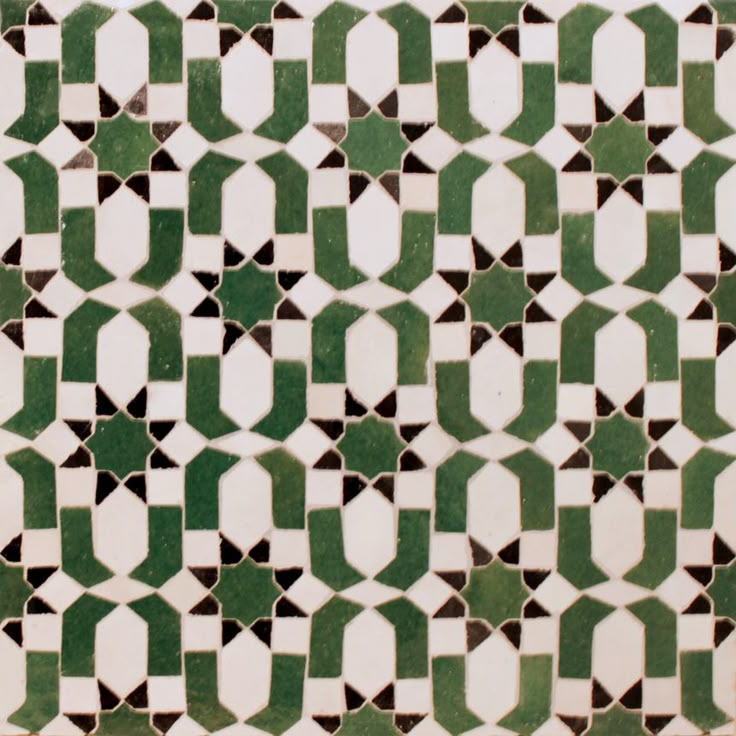 a green and white tiled wall with geometric designs