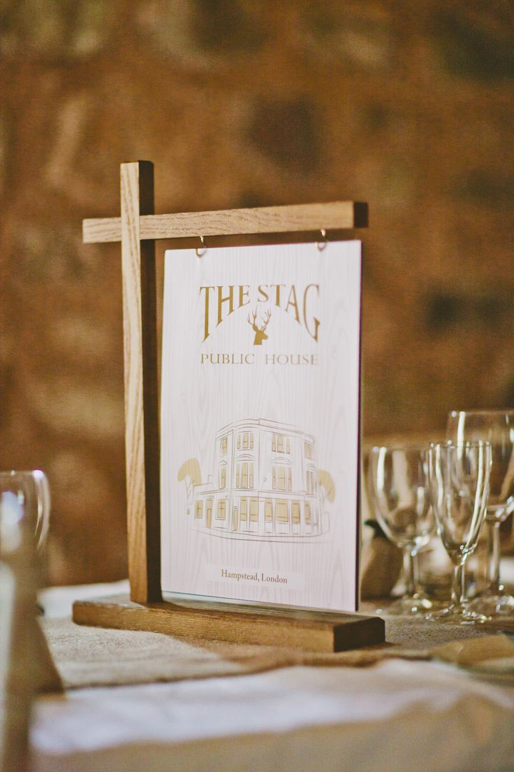 a wooden cross sitting on top of a table next to wine glasses and silverware