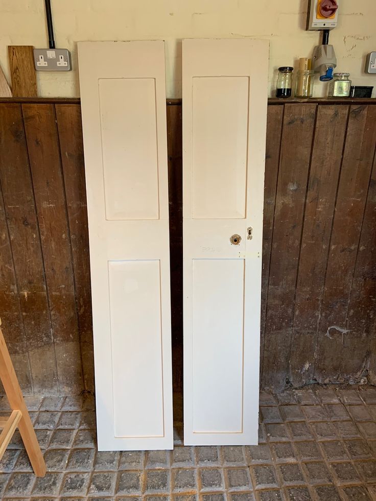 two white doors sitting next to each other in a room