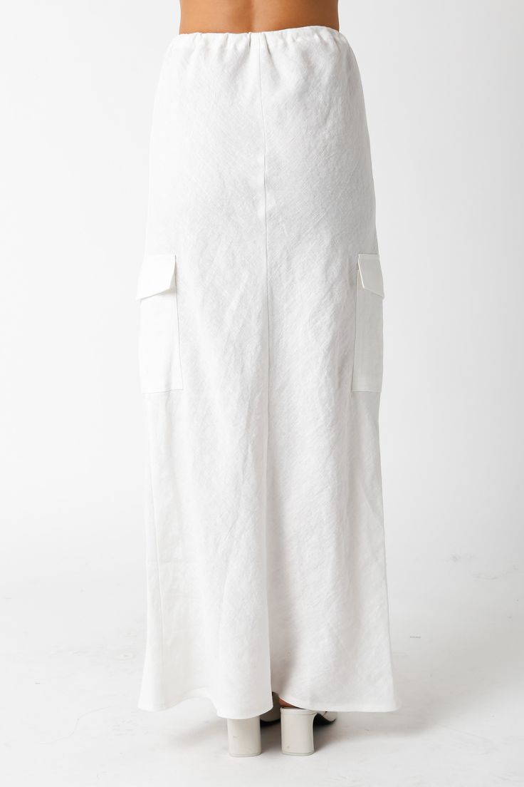 The Kaia White Linen Cargo Maxi Skirt is the perfect vacation cover-up! White linen woven fabric shapes this cargo maxi skirt with a mid-rise fit and drawstring tie. Style with sandals and a cute top and wear to dinner! DETAILS & FIT Loose Fit. 100% Linen. Machine wash cold. Imported. Summer Beach Bottoms With Cargo Pockets, Tiered Maxi Skirt With Pockets For Day Out, Linen Lined Skirt For Vacation, Summer Maxi Bottoms With Pockets, White Maxi Length Summer Bottoms, Spring Beach Bottoms With Cargo Pockets, Cotton Tie-waist Skirt For The Beach, Wide Leg Maxi Skirt With Pockets For Beach, Wide Leg Beach Skirt With Pockets