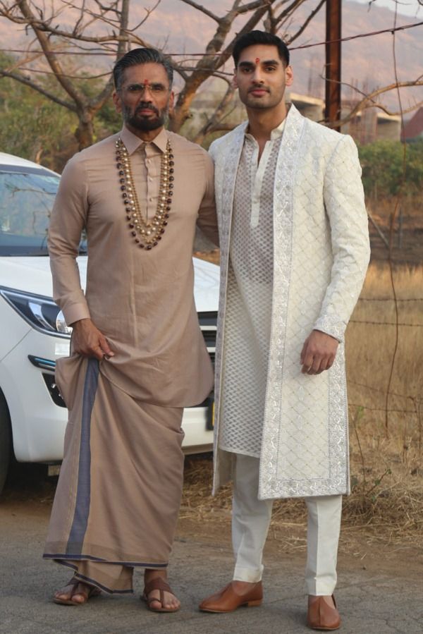 Cricketer KL Rahul and actor Athiya Shetty’s wedding has been one of the most anticipated celebrity shaadis of 2023. The nuptial that took place at actor and Athiya’s father Suniel Shetty’s Bungalow in Khandala was an intimate affair with no-phone policy being the norm for the guests. However, now the pictures from the wedding are out and we can’t keep calm. While we may need to wait some more for the pictures of the ‘couple of the moment’, we have dad and brother Shetty’s pictures out now and t Wedding Brothers Outfit, Sunil Shetty New Look, Bride Father Outfit Indian, Wedding Dress For Brother, Brides Brother Outfit Indian, Brother Wedding Dress For Men, Groom Brother Outfit Indian, Latest Sherwani Designs For Groom, Groom Dress For Wedding