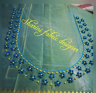 a blue and yellow necklace on display with the words manni hunk designer written in gold