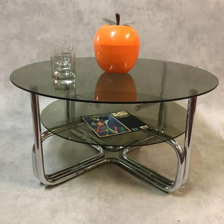 an orange apple sitting on top of a glass table