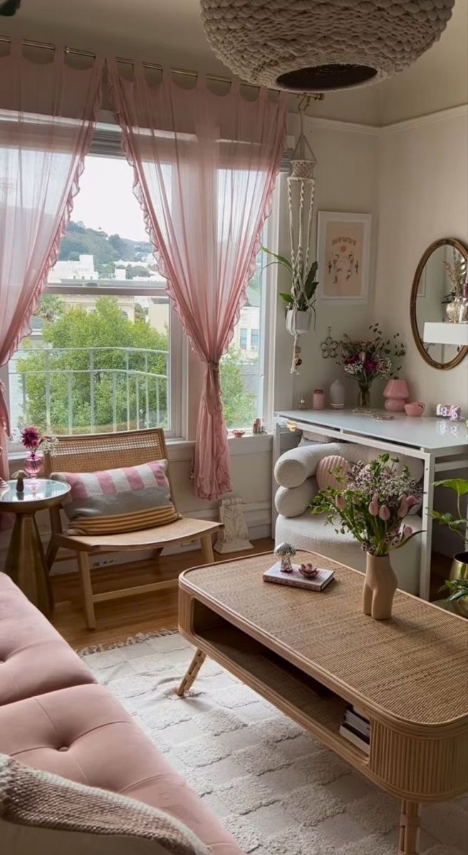 a living room filled with furniture and pink curtains