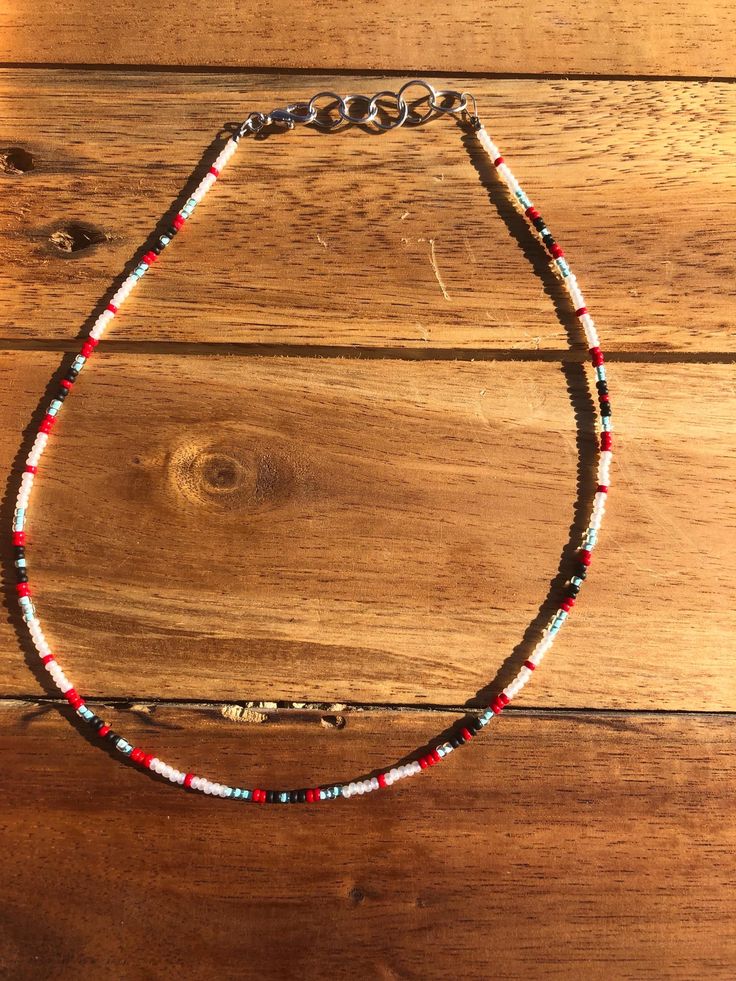 A beautiful hand made seed bead choker, 15 inches long. Gift Heishi Beaded Necklaces With Black Beads, Bohemian Heishi Beads Choker As Gift, Festival Handmade Heishi Beads Choker, Bohemian Beaded Choker Necklace With Spacer Beads, Bohemian Style Beaded Choker With Spacer Beads, Handmade Red Heishi Beads, Festival Polished Bead Choker Necklace, Adjustable Beaded Choker, Bohemian Black Beads Choker Necklace