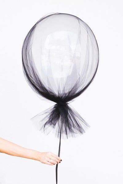 a woman holding a black and white balloon