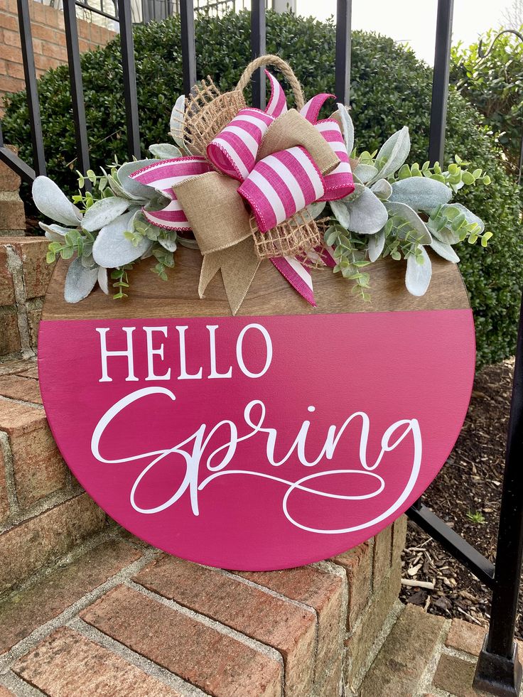 a pink sign that says hello spring on it