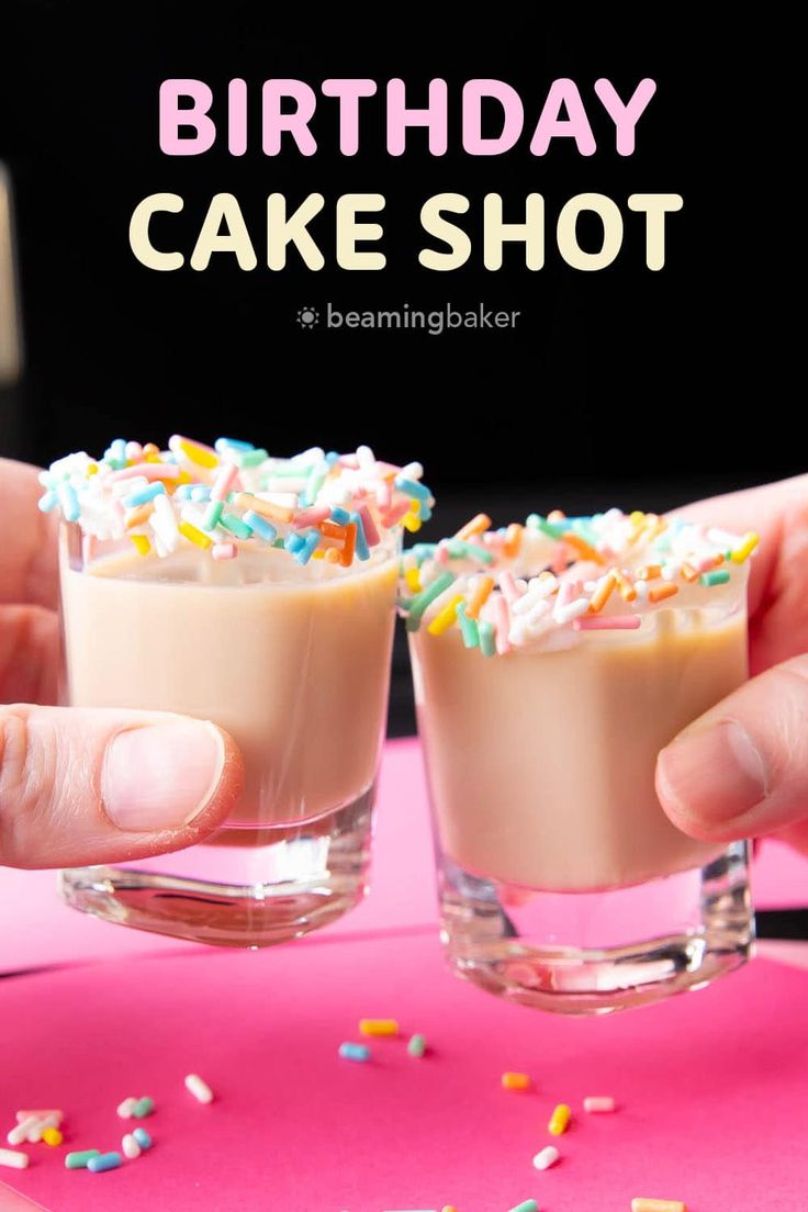 two people holding glasses filled with cake shot and sprinkles on the table