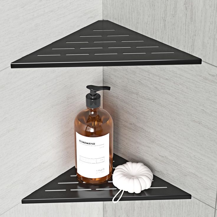 two black shelves with soap and lotion bottles on them next to a white ball