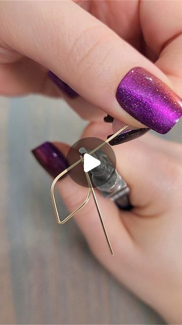 a woman's hand with purple and gold nail polish