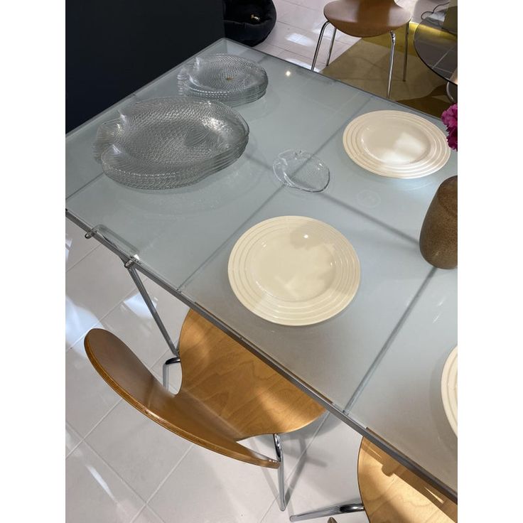 a glass table with plates and bowls on it