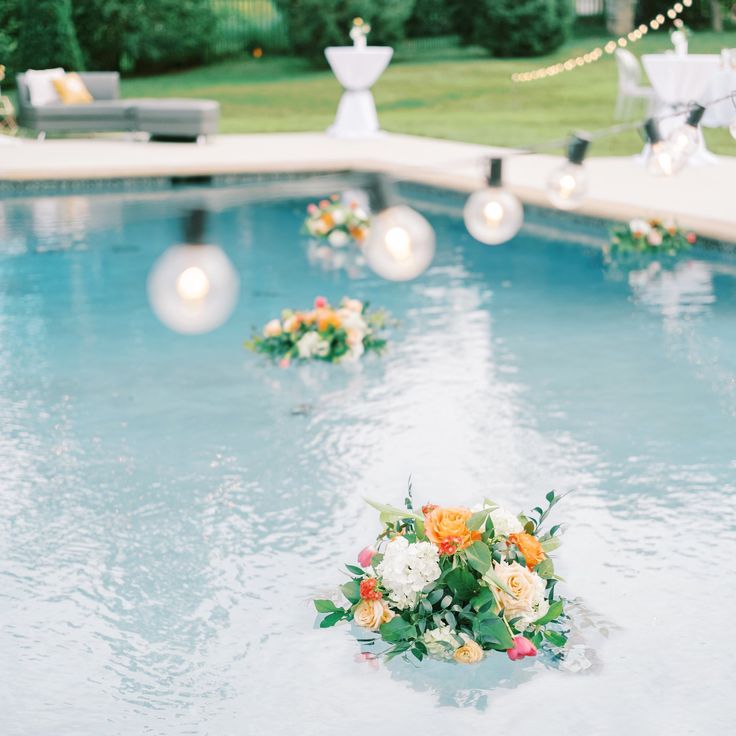 an outdoor pool decorated with flowers and candles