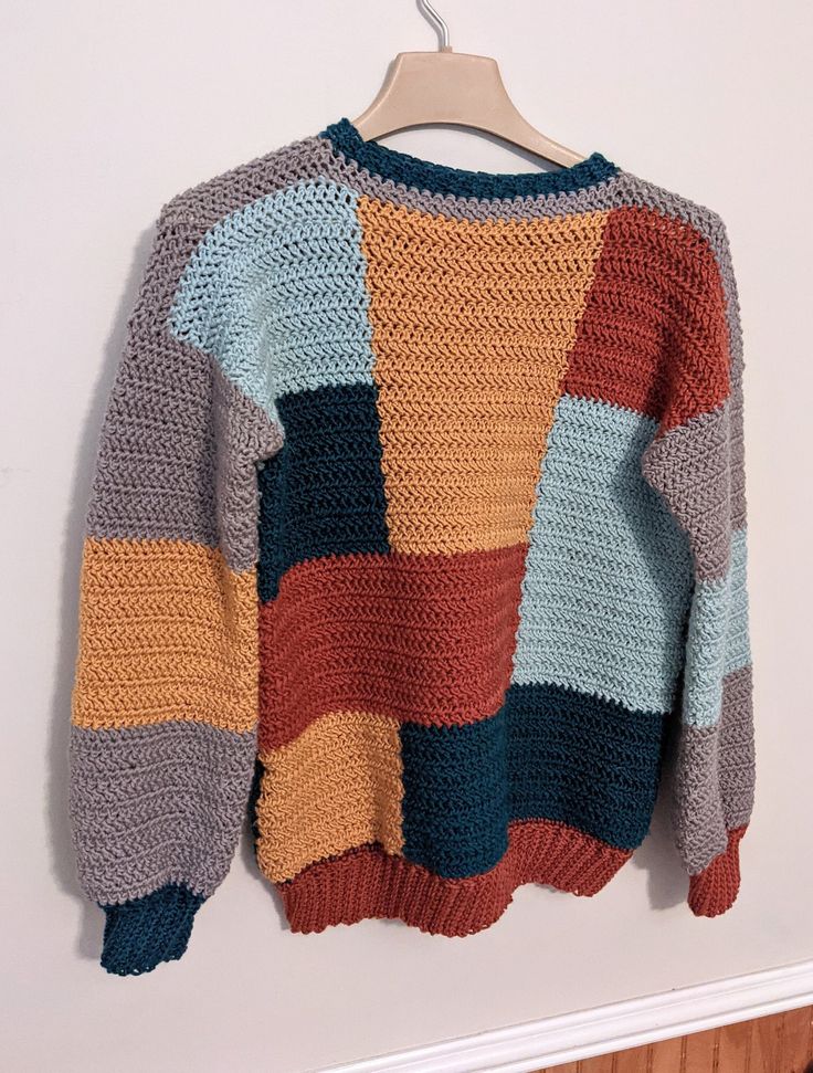 a multicolored sweater hanging on a wall