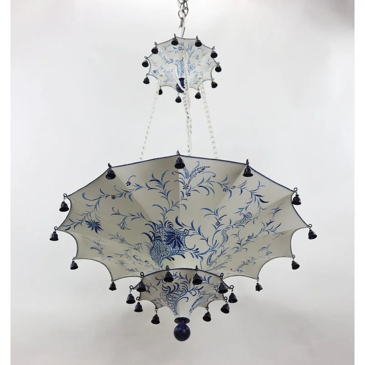 a chandelier with blue and white designs hanging from it's sides on a chain