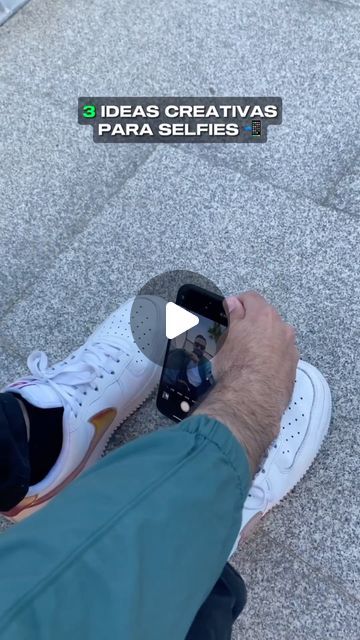 a man sitting on top of a skateboard next to a person holding a cell phone