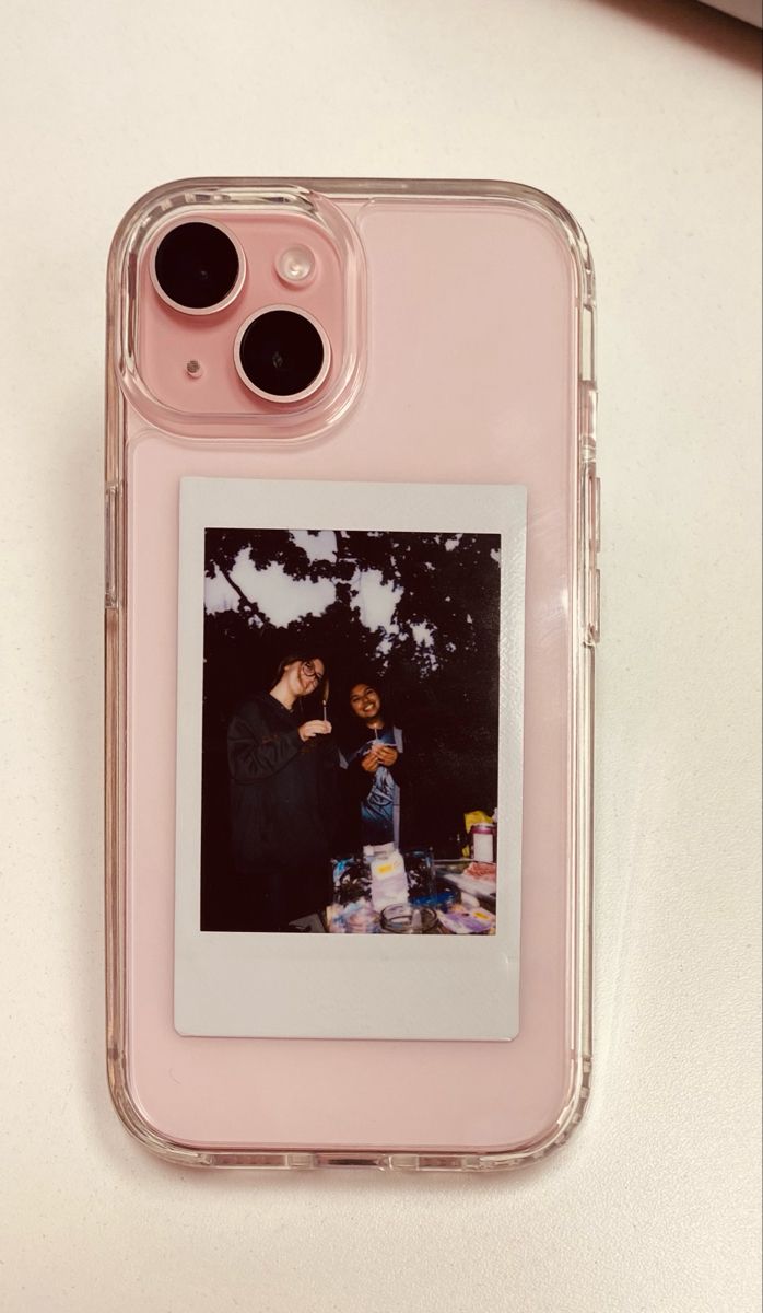 an iphone case with two photos on the back and one in front, sitting on top of a table