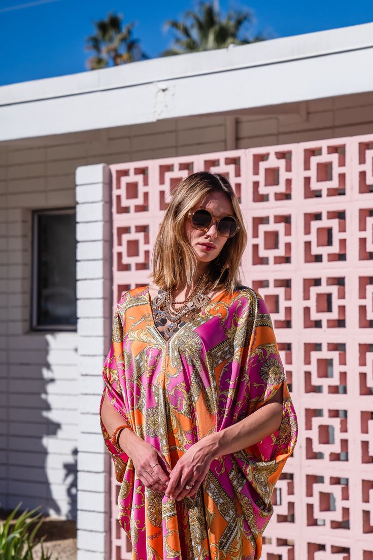 This colorful caftan is the answer to glam layering.. This exquisite garment is more than just a piece of clothing; it's a celebration of fabric in all its glory. Crafted with generous amounts of a ultralight satin rayon and lots of love, this piece offers an airy fit designed to drape beautifully on all body types. Whether worn poolside for a day at the cabana or layered and adorned with your favorite accessories for a glamorous evening affair, it's a versatile wardrobe staple that effortlessly Hippie Multicolor Kaftan With Kimono Sleeves, Multicolor Silk Tunic, Multicolor Boho Print Hippie Kaftan, Hippie Multicolor Boho Print Kaftan, Bohemian Flowy Kaftan With Vibrant Print, Flowy Bohemian Kaftan With Vibrant Print, Pink Vibrant Print Kaftan For Vacation, Festival Free Size Kaftan With Vibrant Print, Festival Kaftan With Vibrant Print And Kimono Sleeves