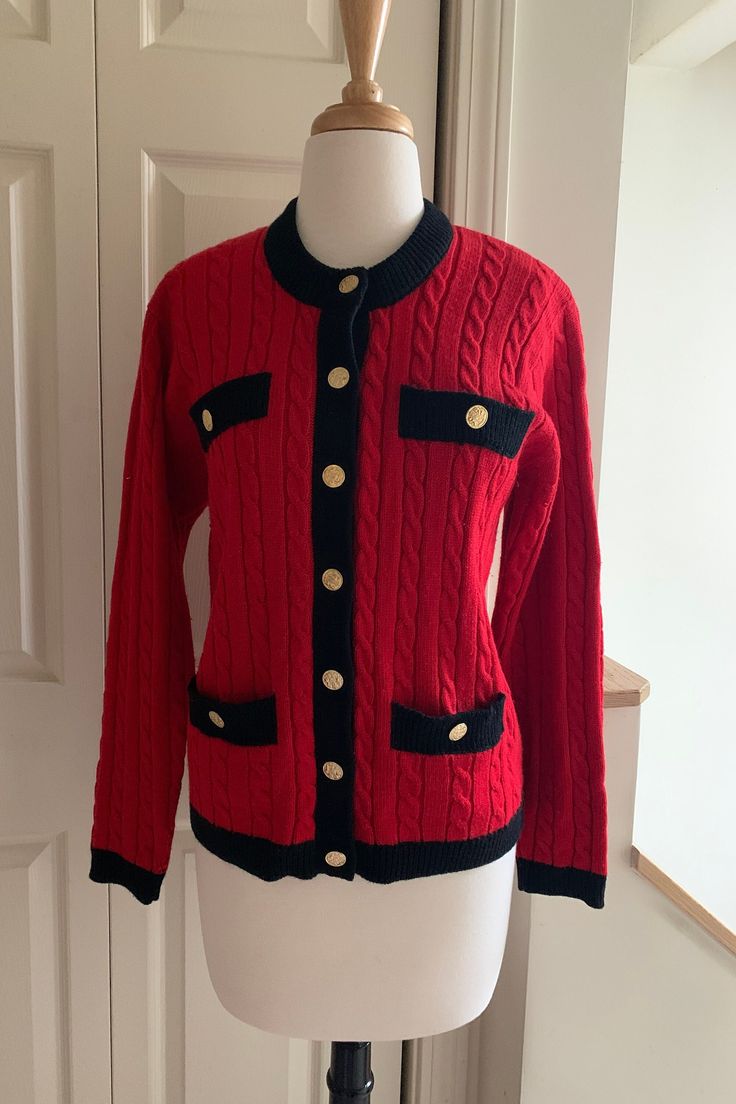 Wonderful classic fully-fashioned Chanel-style sweater jacket. 48% wool, 52% acrylic. Two faux breast pockets, two real buttoned hip pockets. Sleeves have finished tab and button detail. Cable and wide rib stitch patterning, size Medium.  Dimensions: Body 36" circumference  Shoulder width 15 1/2" Length shoulder to hem 23 1/2" Sleeve length 22 1/2" Fitted Button-up Sweater With Pockets, Classic Long Sleeve Cable Knit Outerwear, Retro Fall Sweater For Workwear, Retro Workwear Sweater For Fall, Retro Fall Sweater For Work, Classic Button-up Sweater With Buttoned Pockets, Classic Winter Sweater Coat With Pockets, Classic Fitted Sweater With Pockets, Red Knit Outerwear With Buttons