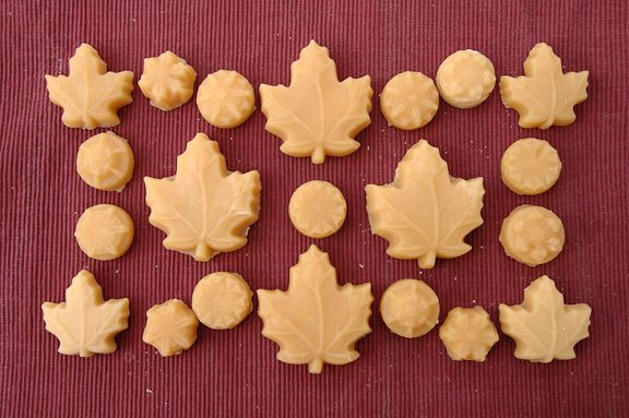 maple leaf shaped cookies sitting on top of a red tablecloth next to each other