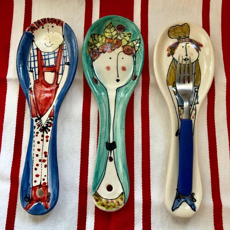 three spoons are sitting next to each other on a striped tablecloth with red and white stripes