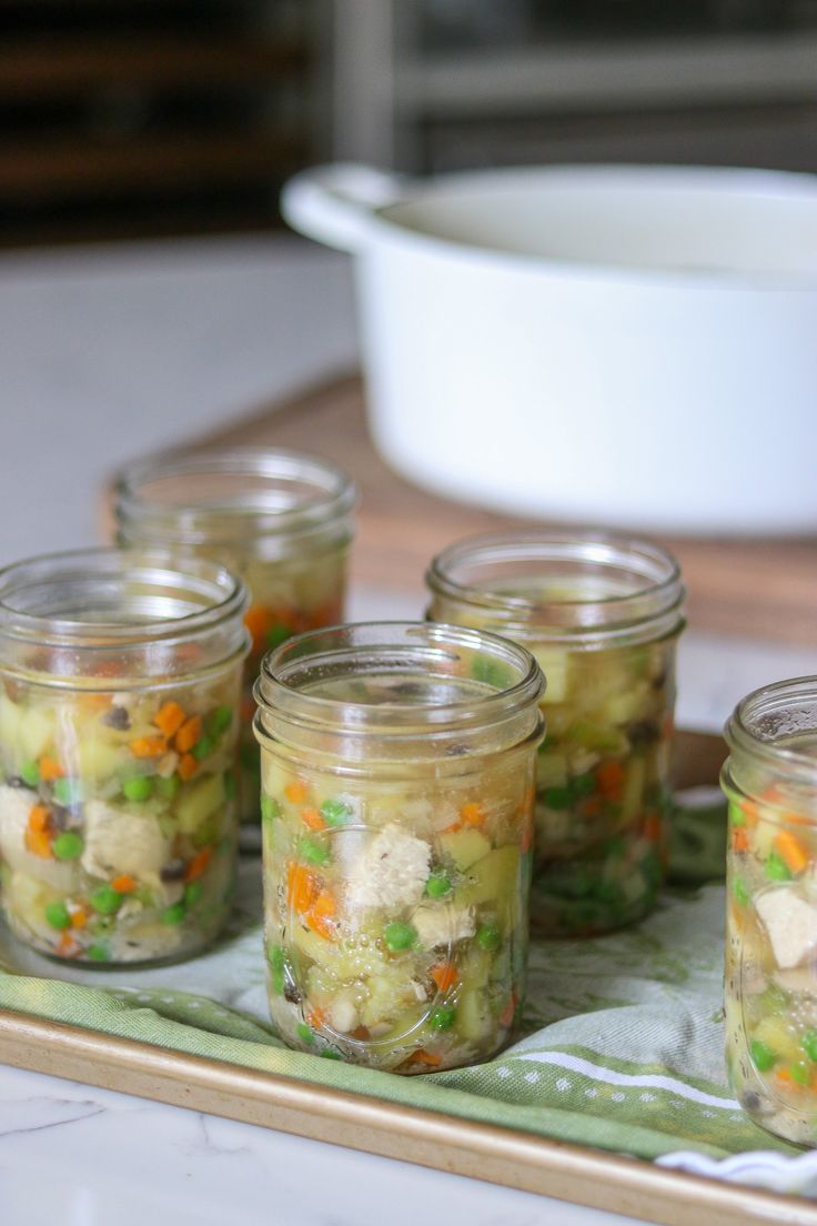 four jars filled with food sitting on top of a table