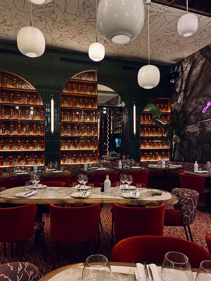 the dining room is set with red chairs and round tables in front of bookshelves