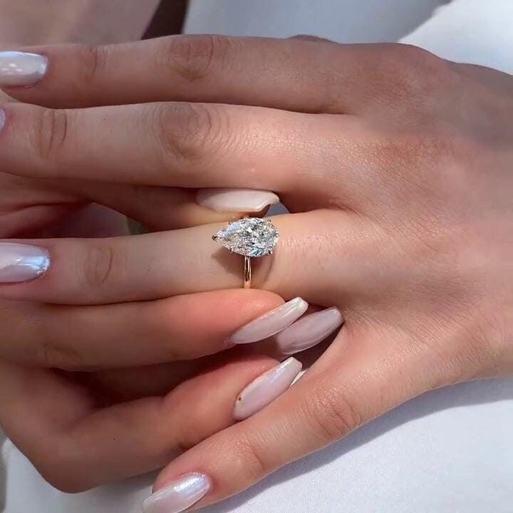 a woman's hands with manicured nails and an engagement ring