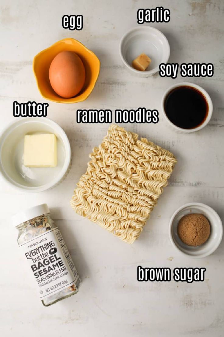 ingredients needed to make noodle soup laid out on a white counter top, including eggs, butter, ramen noodles and brown sugar