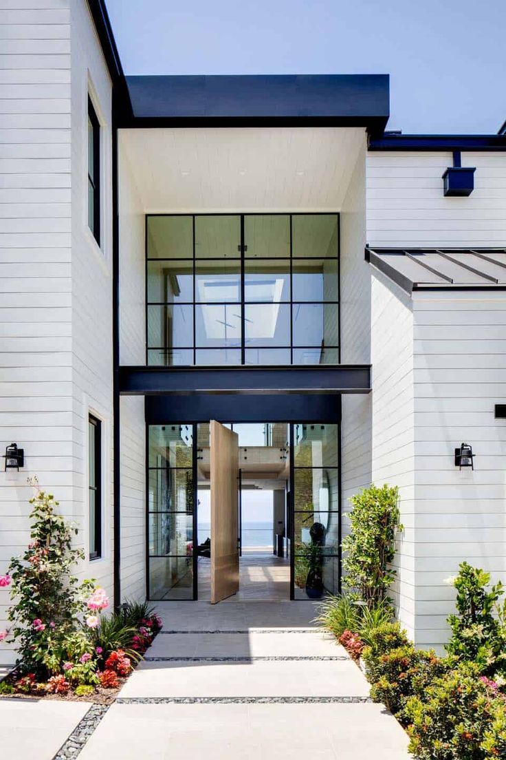 an entrance to a white house with lots of windows