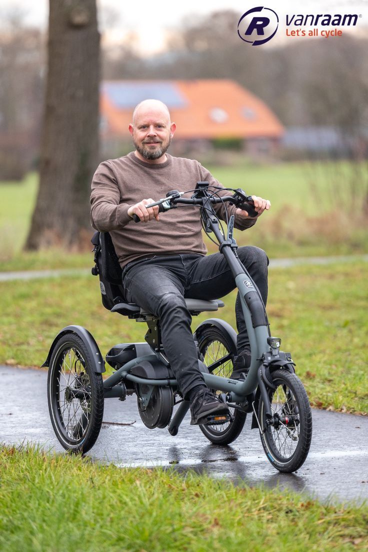 a man riding an electric scooter on a path in the park with trees