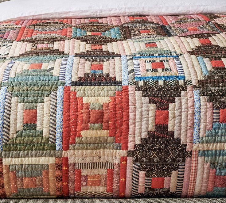 a bed with a colorful quilt on top of it