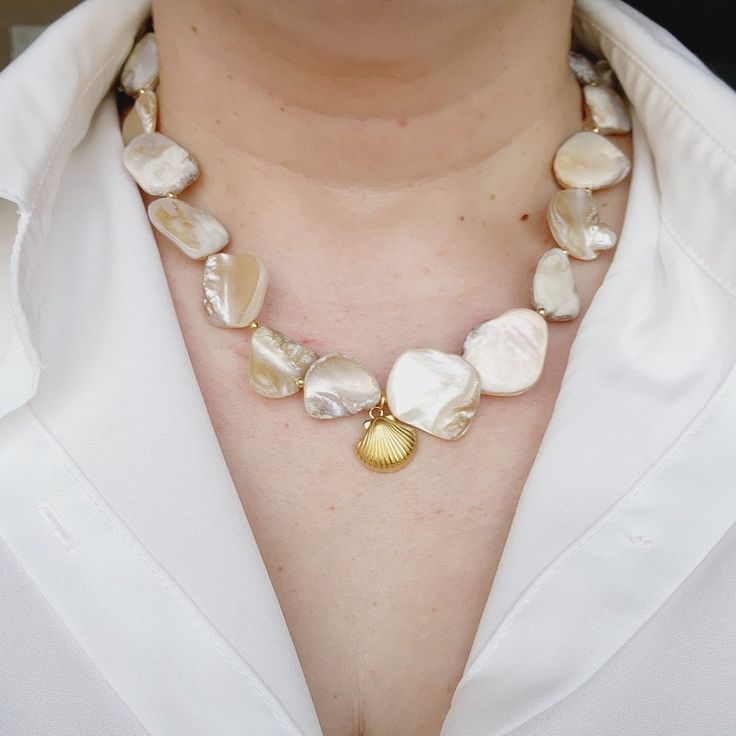 Maui Shelly Necklace has a ivory nacar chain with a shell charm and a toggle clasp. This is a unique and stunning necklace. The details of the pearls will give you a polish look. The baroque Pearls are that classic piece that goes with any trends. Combine Maui Shelly Necklace with Shelly Necklace. Material: Highly polished vacuum 18k Gold Plated & stainless steel for a refined metallic luster, better texture, lasting To Keep Colors! Necklaces come in a Pouch. Necklaces Details: Nacar Chain: 15 inches Stainless Steel & Gold Plated Water Resistance (remember to always clean your jewelry with clear water after you wear them to the pool or to the beach) Does not tarnish and with the right care it can last you for years. Check Our Jewelry Care Instructions. Fashion Tip: Add hops earrings or asy Elegant Shell-shaped Pearl Drop Necklace, Pearl White Shell Necklace With Pearl Pendant, White Mother Of Pearl Shell Necklace With Pearl Pendant, Pearl White Mother Of Pearl Shell Necklace Gift, Pearl White Mother Of Pearl Shell Necklace As Gift, Pearl White Shell Necklace With Pearl Chain As Gift, Shell-shaped Pearl Necklace With Pearl Pendant, Shell Necklace With Pearl Chain, Elegant Shell-shaped Necklace With Pearl Charm