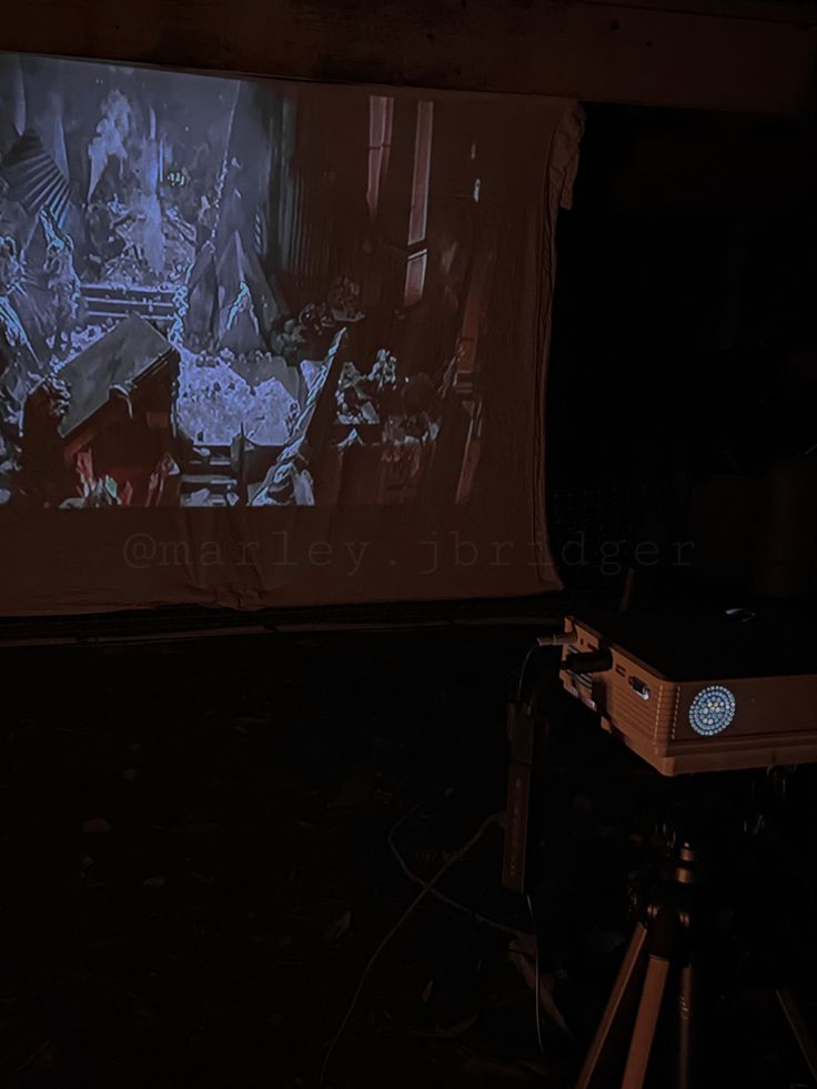 a projector screen is shown in front of a projection on a dark room floor