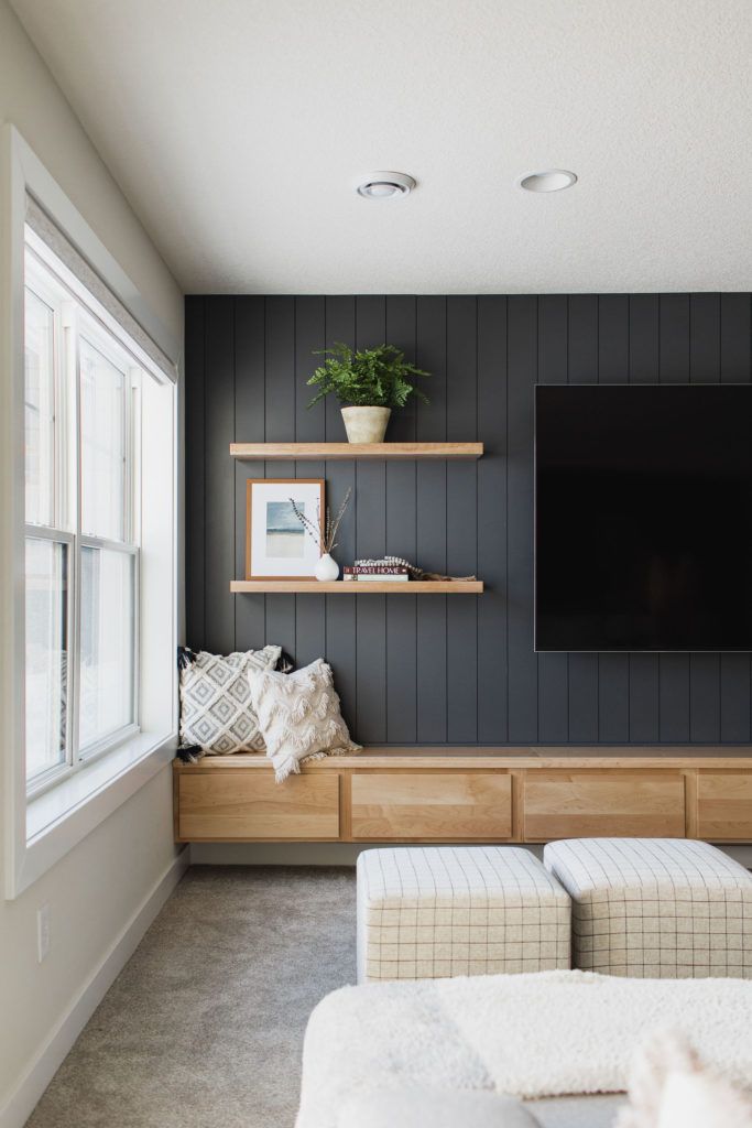 a living room with two couches and a flat screen tv mounted on the wall