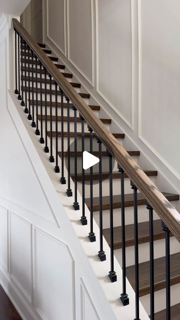 an image of a stair case in a house that is painted white and has wood handrails