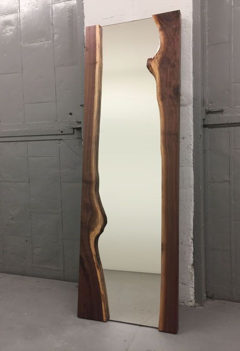 a mirror that is in the middle of a floor next to a wall and door