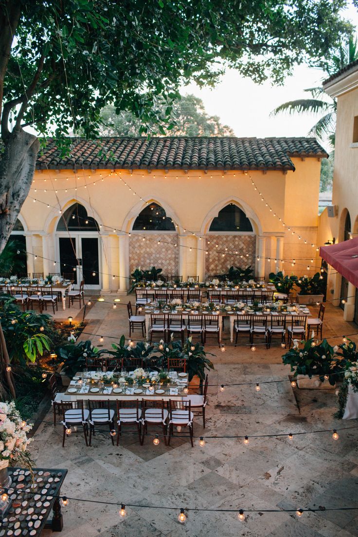 an outdoor venue with tables and chairs set up for a formal dinner or wedding reception