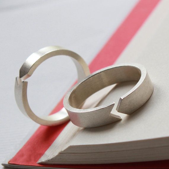 two wedding rings sitting on top of an open book