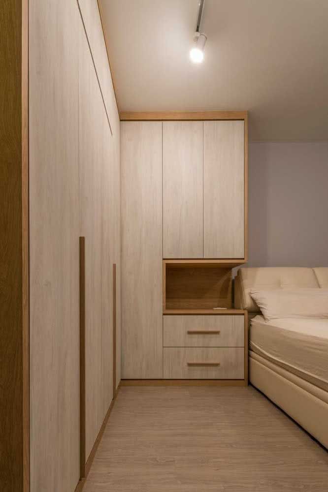 an empty bedroom with white walls and wooden furniture, including a built - in bed