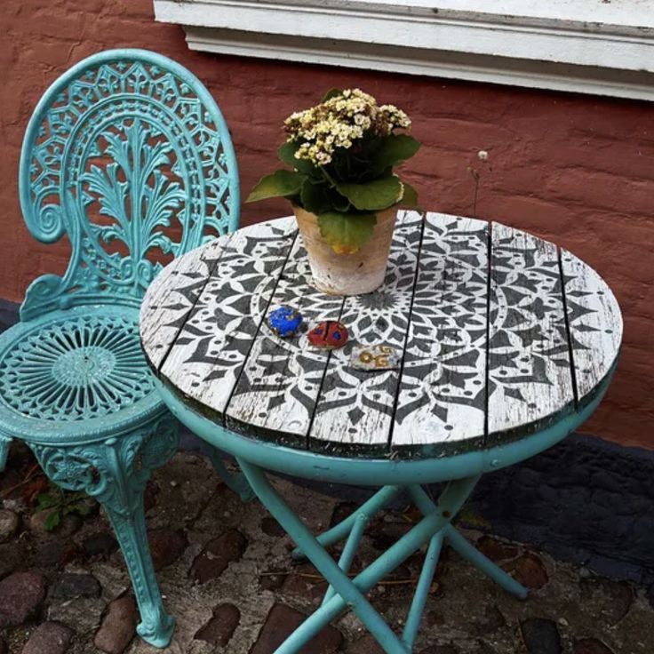 a blue table and chair with a potted plant on top