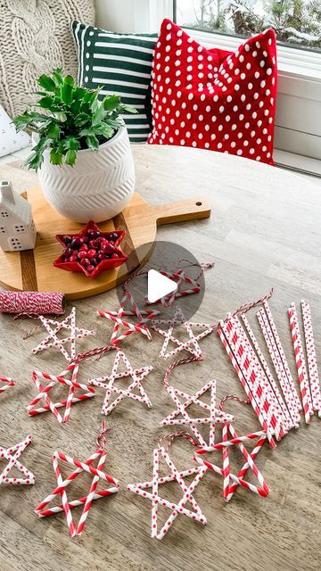 some red and white paper stars on a wooden table next to a potted plant