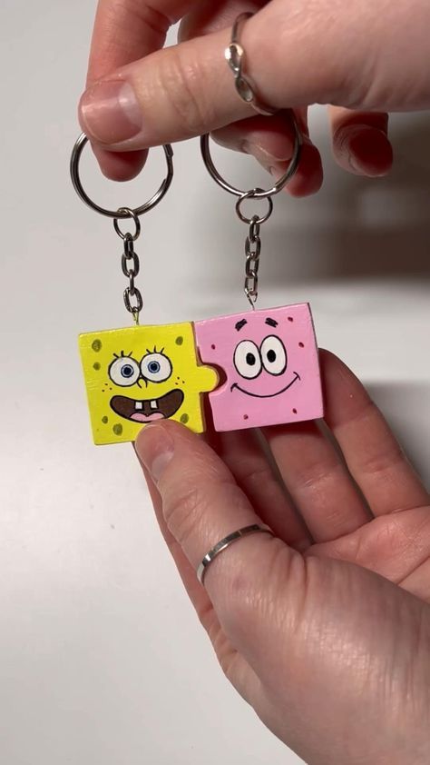 someone is holding two spongebob key chains