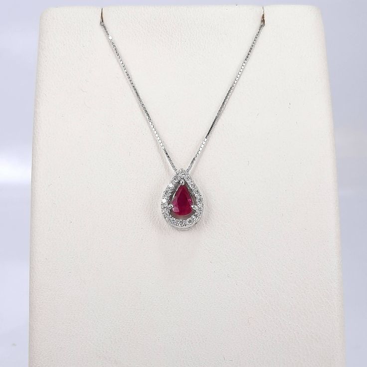 "White gold 14k necklace set with a pear shaped natural ruby 6×4 mm, 0.45 carat, surrounded by 16 halo round diamonds of 0.14 carat weight VS-G grade. Including a box chain 18\" Long. The ruby and diamonds are 100% natural of a very high quality, the diamonds are full of sparkle. The pear shape ruby weights 0.45 carat is full of rich color, surrounded by a halo of 16 diamonds of 0.14 carat VS-G Gold: 14k 1.90 gram (approx.) Chain: 16\"/18\"/20\" long Ruby: 0.45 carat, 6x4 mm, the ruby is natural Red Diamond Teardrop Necklace, Red Teardrop Diamond Necklace, Ruby Teardrop Pendant Necklace, Ruby Gemstone Teardrop Pendant Necklace, Formal Pear-shaped Ruby Necklace, Elegant Ruby Teardrop Pendant Necklace, Red Diamond Teardrop Pendant Necklace, Teardrop Fine Jewelry Necklace With Halo Setting, Fine Jewelry Teardrop Necklace With Halo Setting